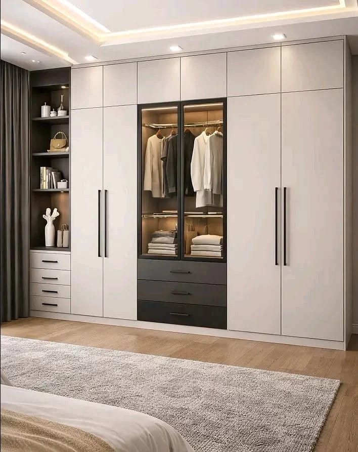 Floor-to-ceiling wardrobe with a lit glass centre, dark drawers and open styling niche